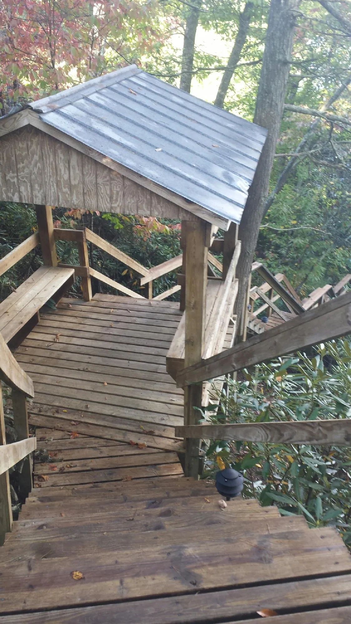 Metal roofed shelter over wooden steps on a wooded walkway — Skylight Repair & Installation work by our crew in Allport