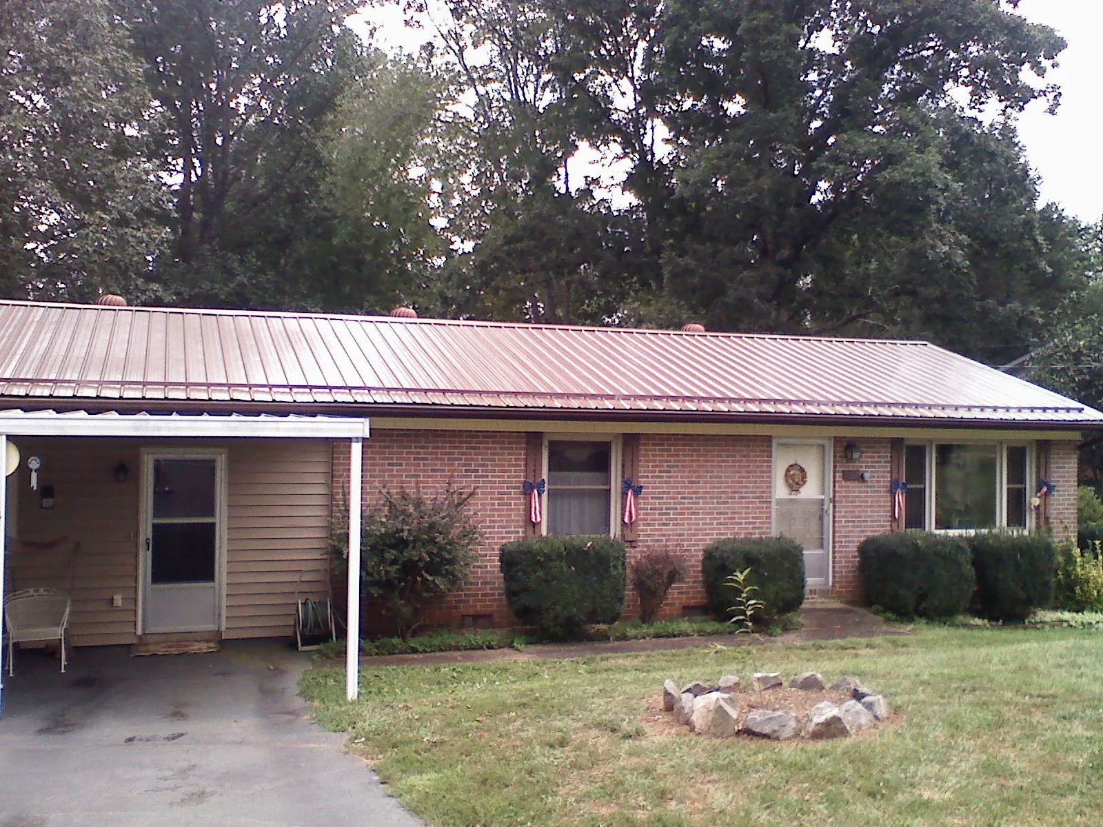 Bronze metal roof and carport on a brick ranch home — Roof Repair work by our crew in Allport